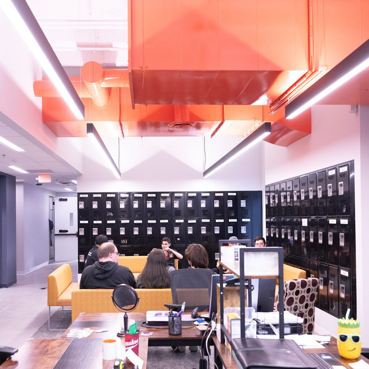 The open workspace at 3017 during the Lake Street Works grand opening, with students, mentors, and rows of lockers